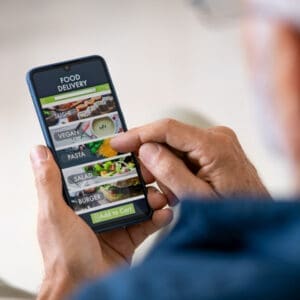 A man uses a mobile phone to find plant-based restaurants