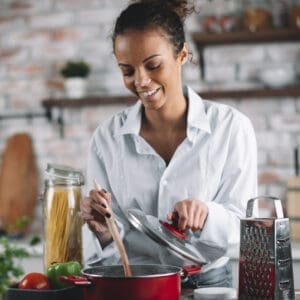 A woman cooks vegan pasta in the kitchen