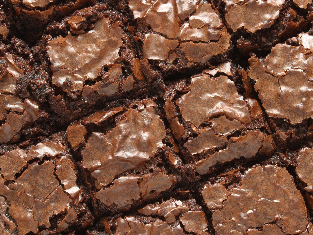 A batch of vegan brownies cut into squares in a pan.