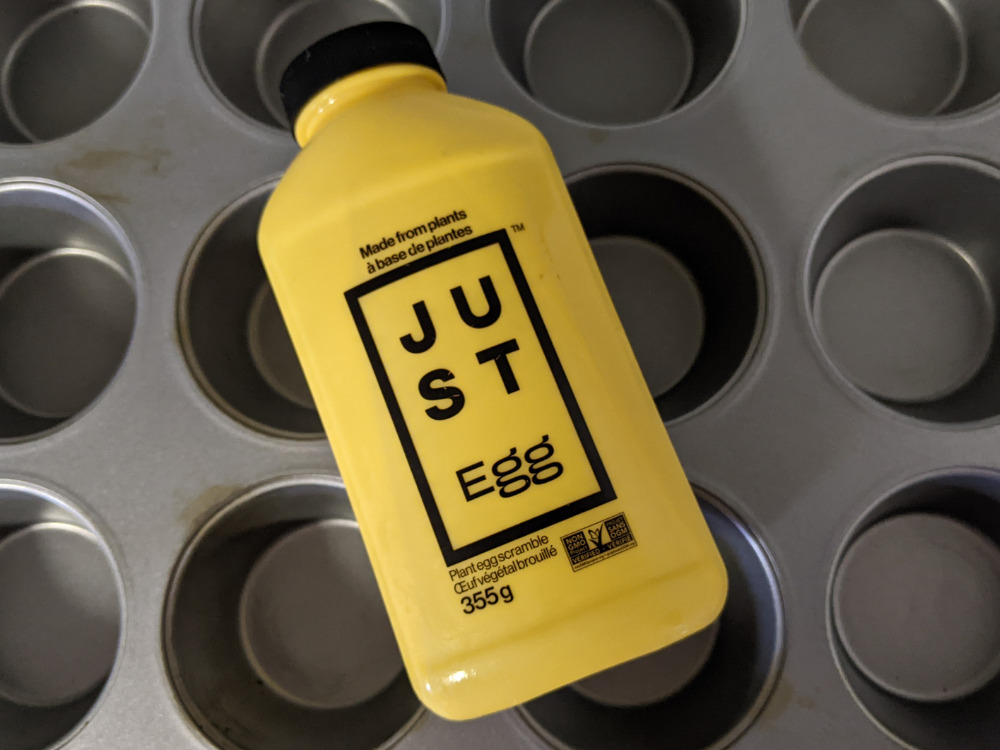 A bottle of Just Egg vegan egg replacement on a muffin tin.