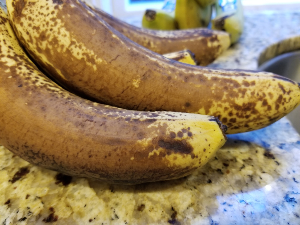 A bunch of overripe bananas on the counter.