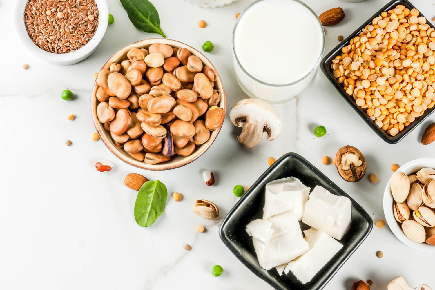 Various protein-rich plant-based foods on a white table.